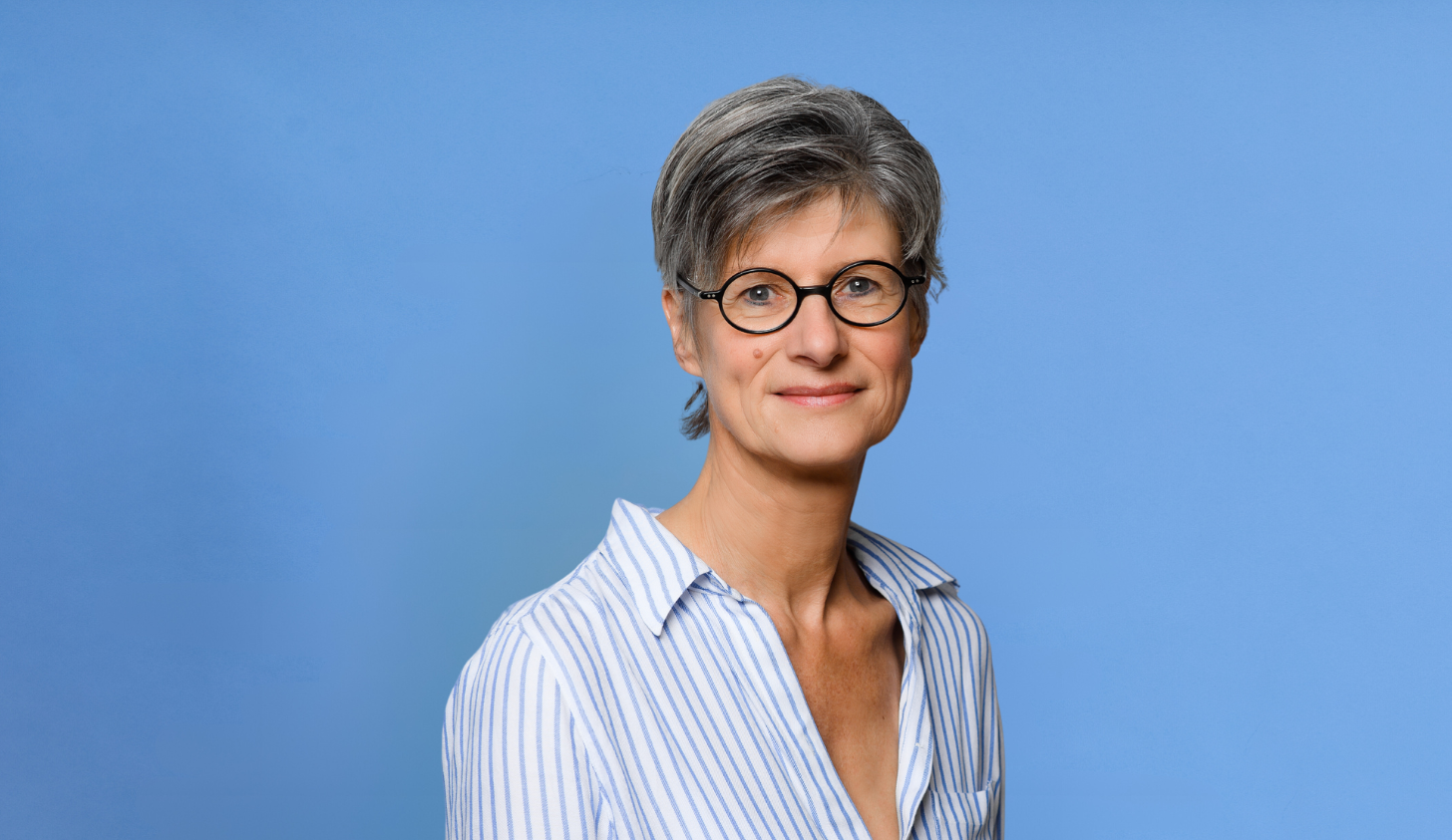 Foto zeigt Frau Dr. Barbara Heiden mit blauem Hintergrund