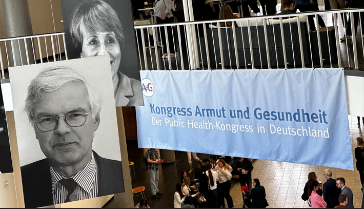 Banner for the Public Health Congress in Germany with attendees in the background.