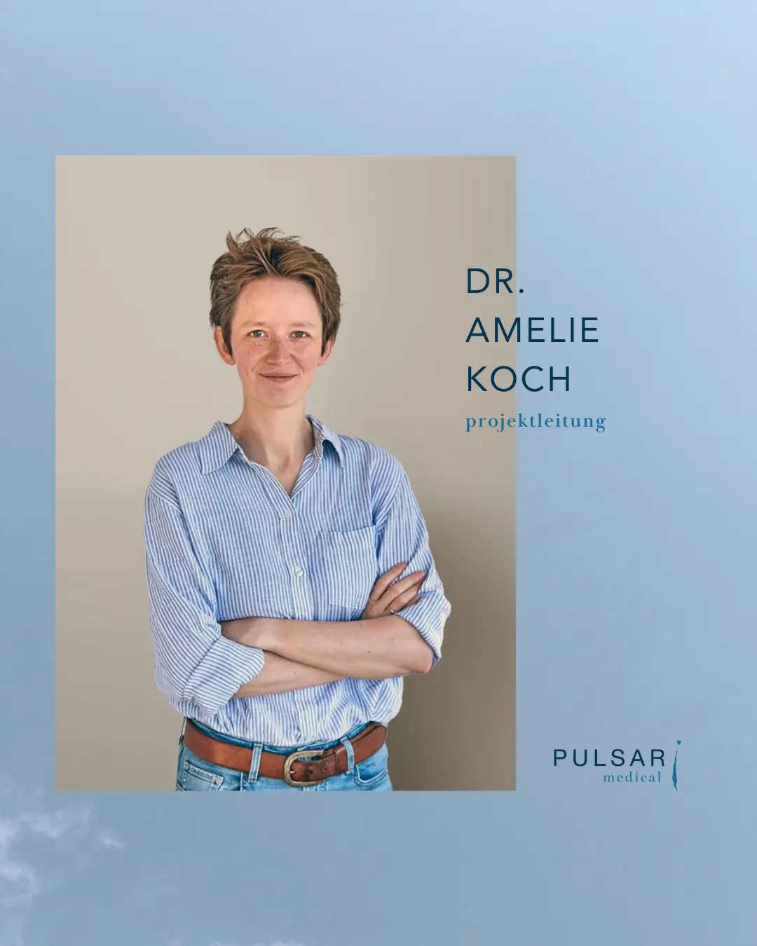 Porträt von Dr. Amelie Koch, die mit verschränkten Armen in einem hellen Hemd steht.