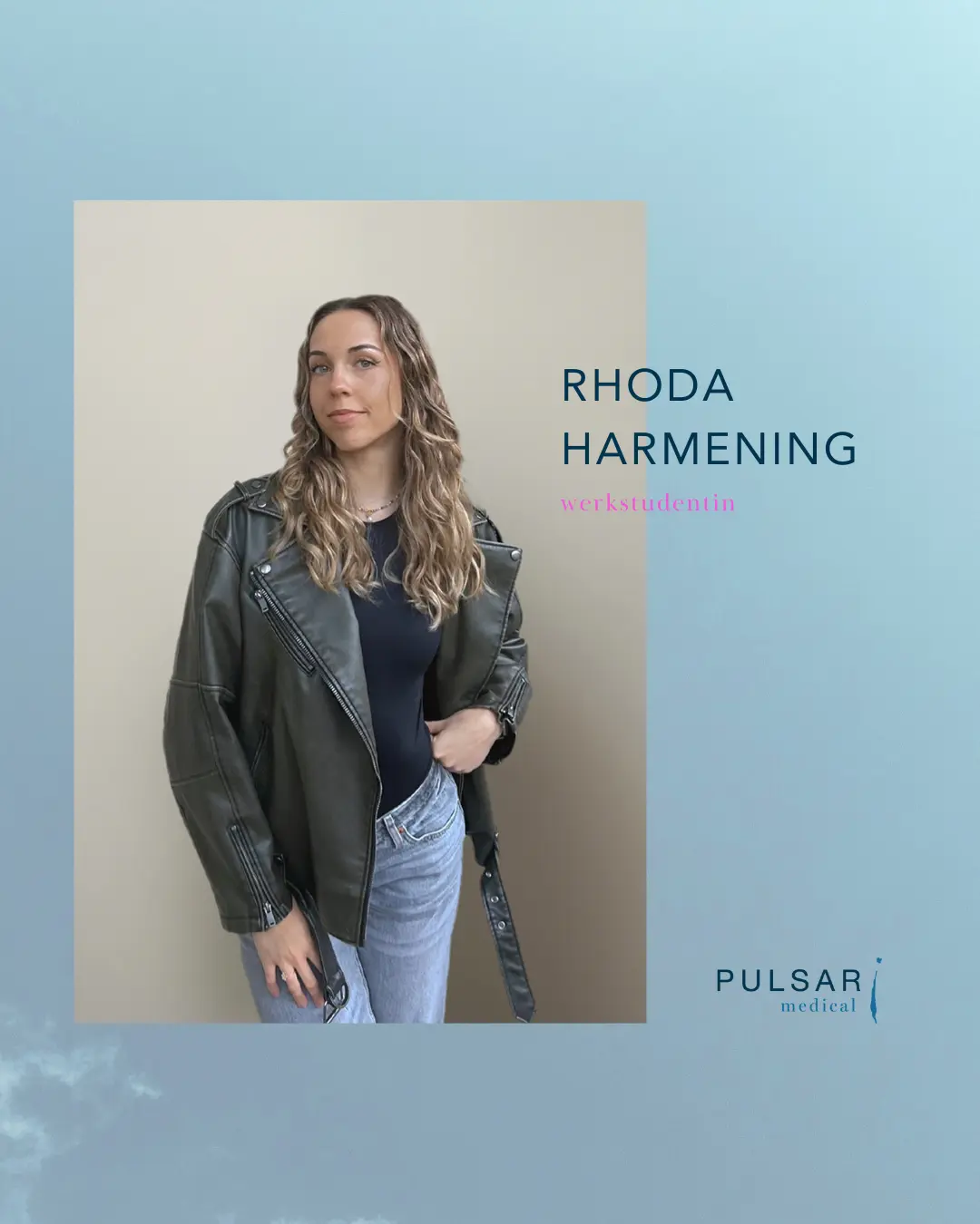 Frau mit langen, lockigen Haaren, die eine schwarze Bluse und eine grüne Lederjacke trägt.